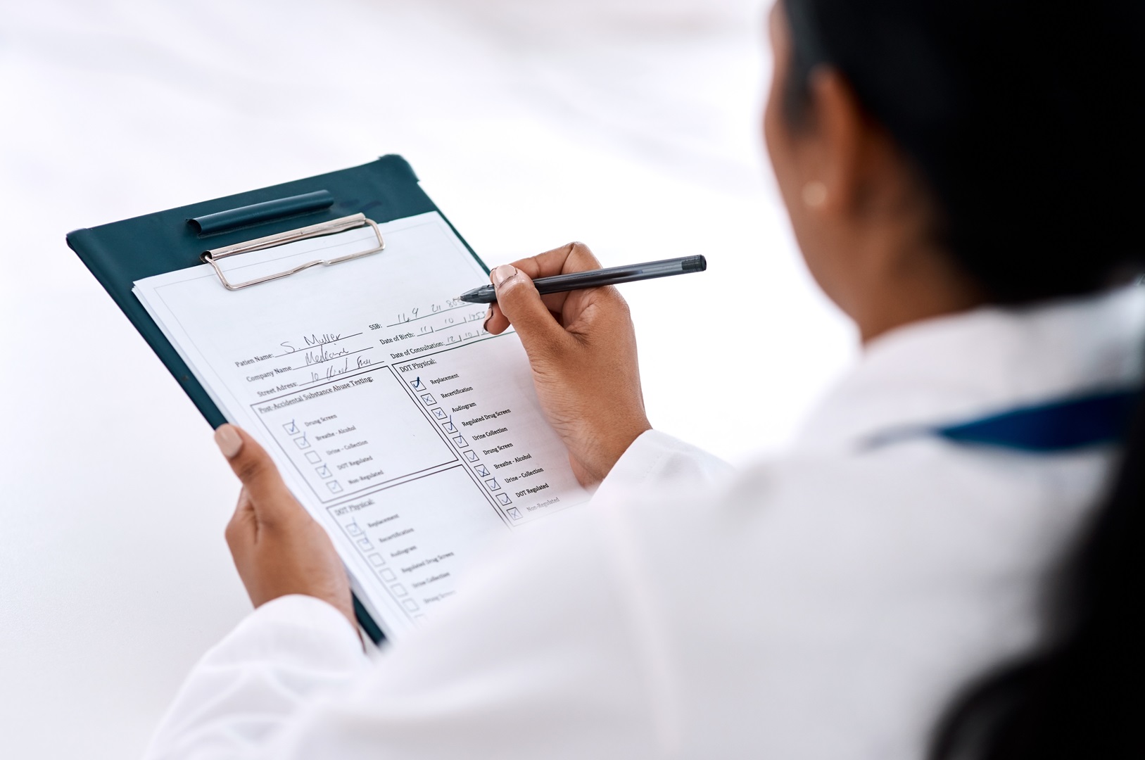 Physician checking clipboard with CPT codes to avoid overcoding, overbilling