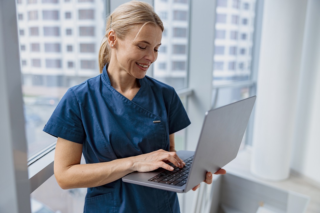 Physical therapist using laptop to perform SOAP note-taking with AI